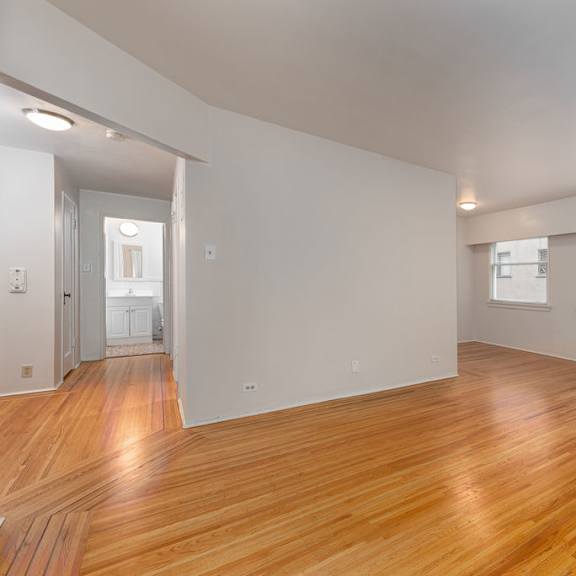 a bedroom with a medium hardwood floor and white walls