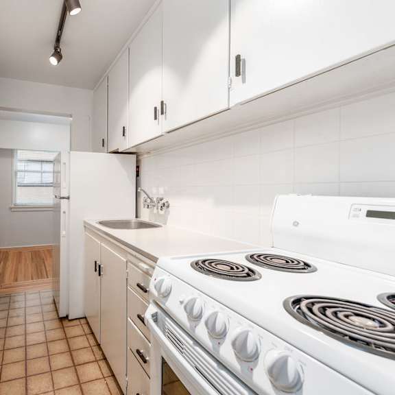 a kitchen with white cabinets and a white stove top oven
