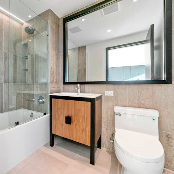 a modern bathroom with a wooden cabinet and a white toilet.