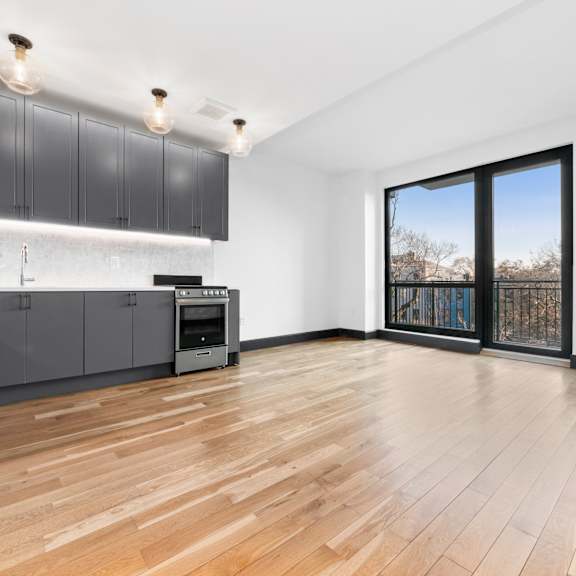 a kitchen with wooden floors and a large window.