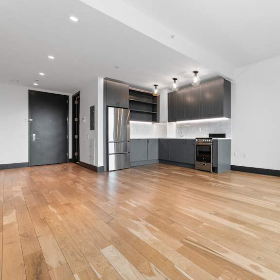 a kitchen with a refrigerator, oven, and sink.