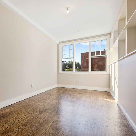 empty room with wooden floors and a window.