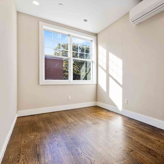 a room with a window and wooden floors.