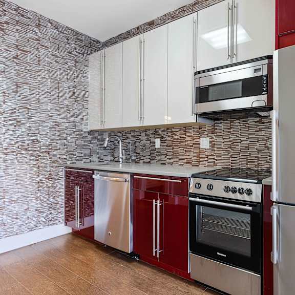 a kitchen with a refrigerator, oven, and microwave.