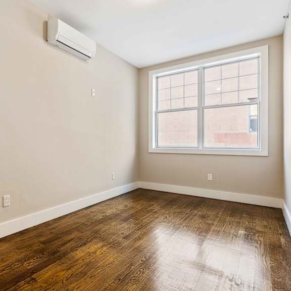 a room with a window and wooden floor.