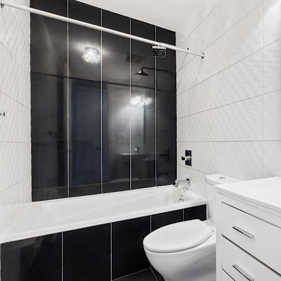 a white bathroom with a toilet, sink, and bathtub.