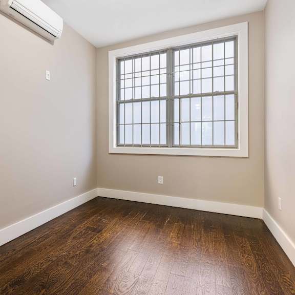 a room with a window and wooden floor.