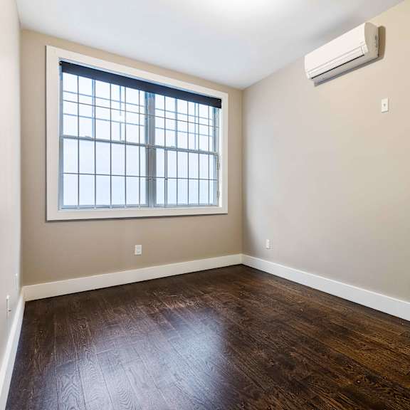 a room with a window and a wall-mounted air conditioner.