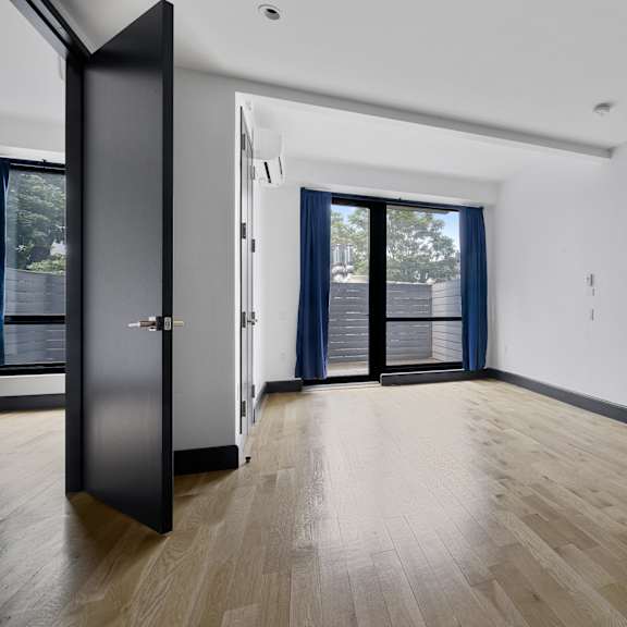 a room with a black door and wooden flooring.