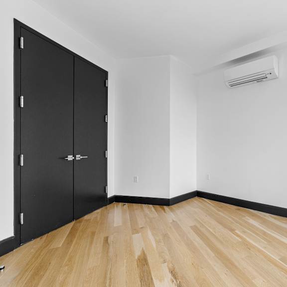 a room with black cabinets and wooden flooring.