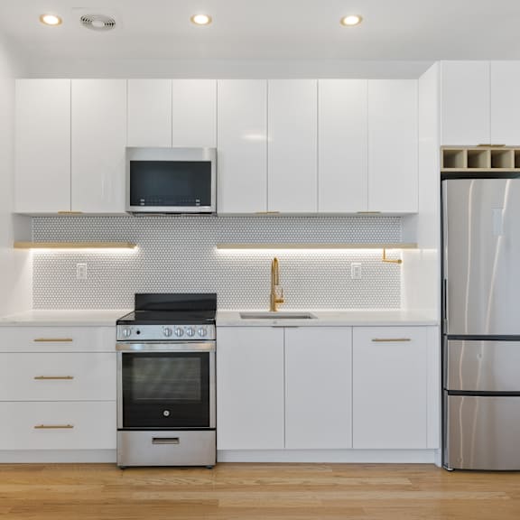 a kitchen with white cabinets and stainless steel appliances