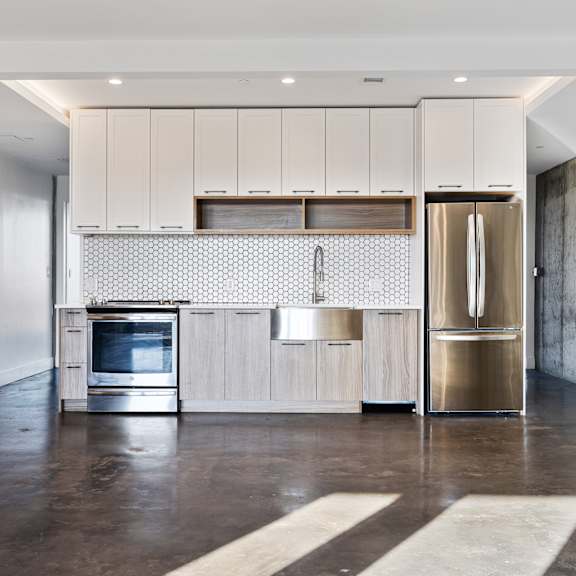 a modern kitchen with a refrigerator, oven, and cabinets.