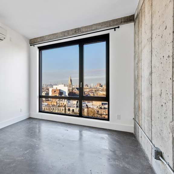 a large empty room with a view of a cityscape through a large window.