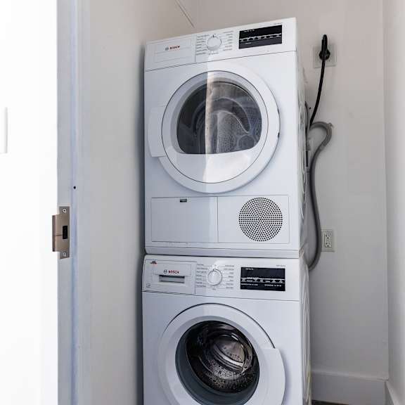 two white front loading washing machines in a laundry room.