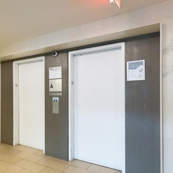 a hallway with two doors, one of which is closed and has a sign on it.