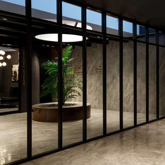 a lobby with glass doors and a potted plant