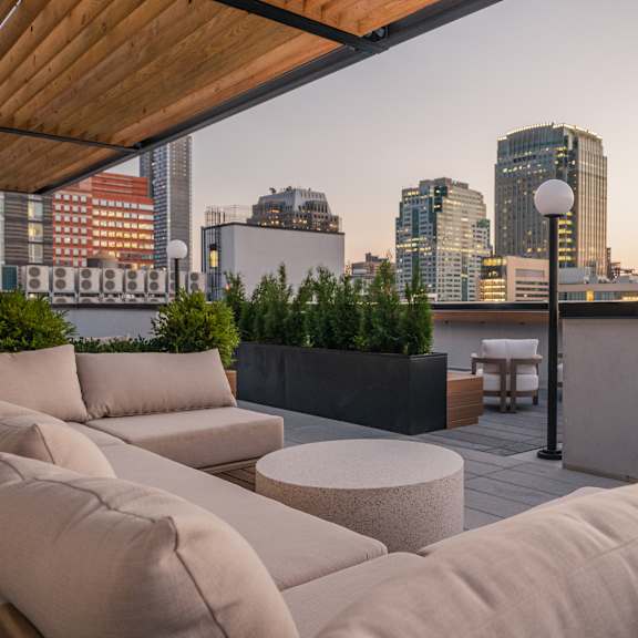 a living area with couches and a table on a balcony overlooking the city