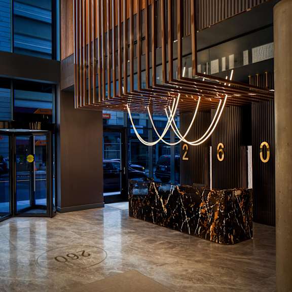 the lobby of the building has a marble reception desk and a large number of lights