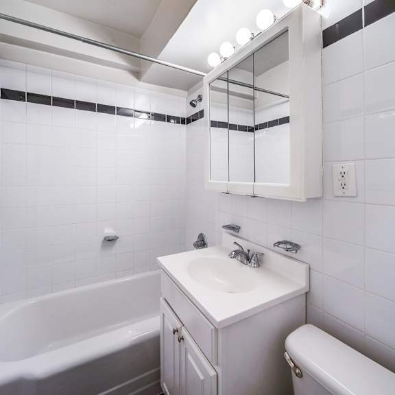 a white bathroom with a tub, sink, and toilet.