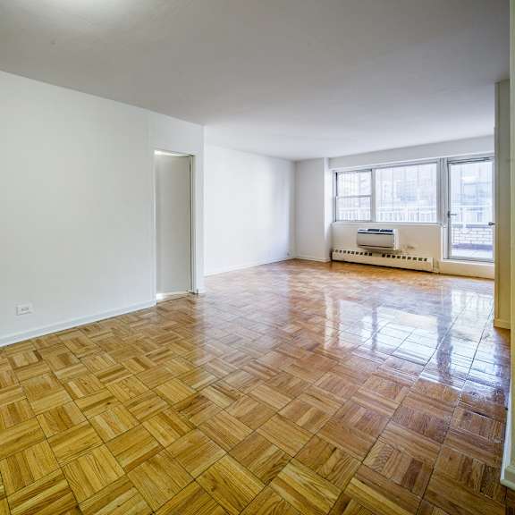 a room with wooden flooring and white walls.