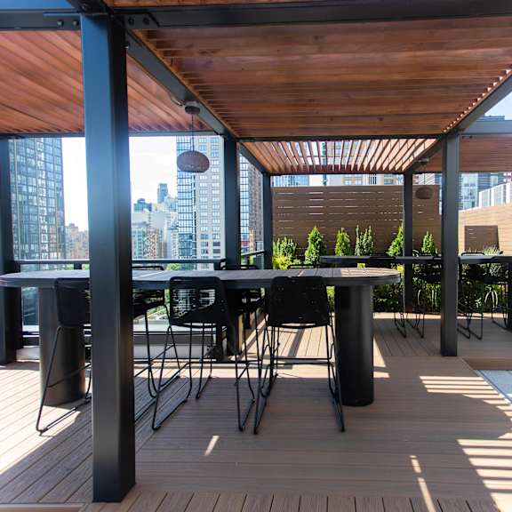 rooftop pergola with dining space and wood slat ceiling at 260 gold apartments, brooklyn, new york