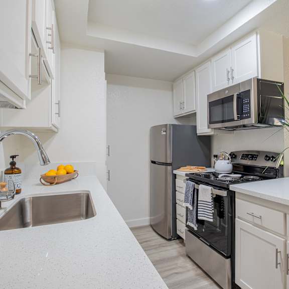 a kitchen with white cabinets and stainless steel appliances  at metro 3610, riverside, 92505