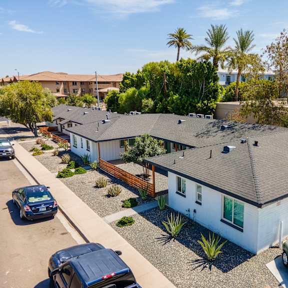 an aerial view of a row of houses with cars parked in front of them
