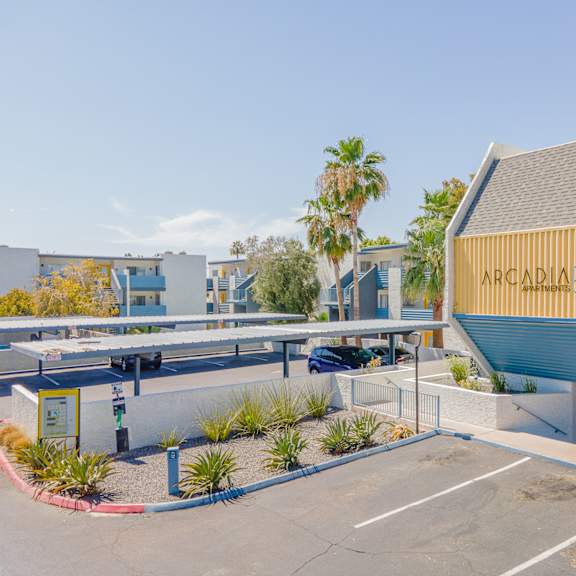 a parking lot with a yellow and blue building with the words arcadia on it