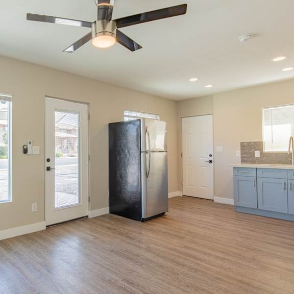 a kitchen and living room with a large window and a ceiling fan