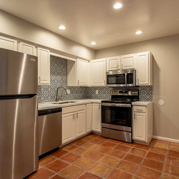 a kitchen with stainless steel appliances and white cabinets