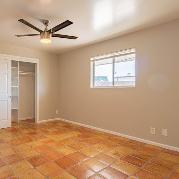 an empty room with a ceiling fan and a window