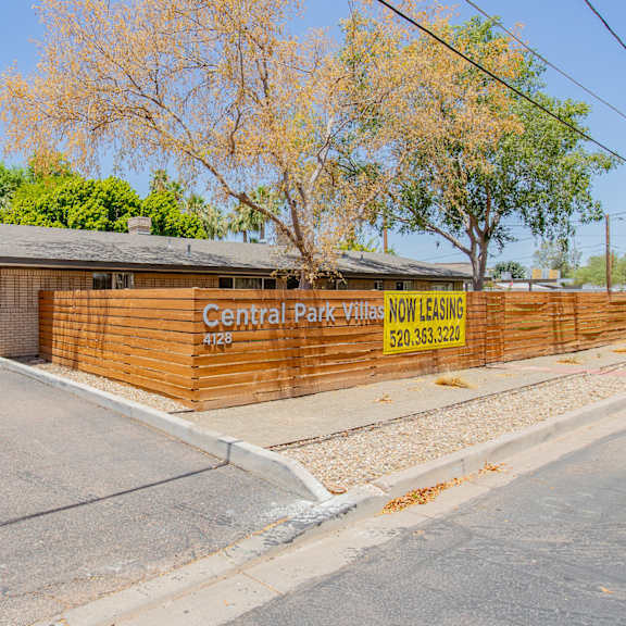 a wooden fence in front of a building with a yellow sign that says central pacific nursing