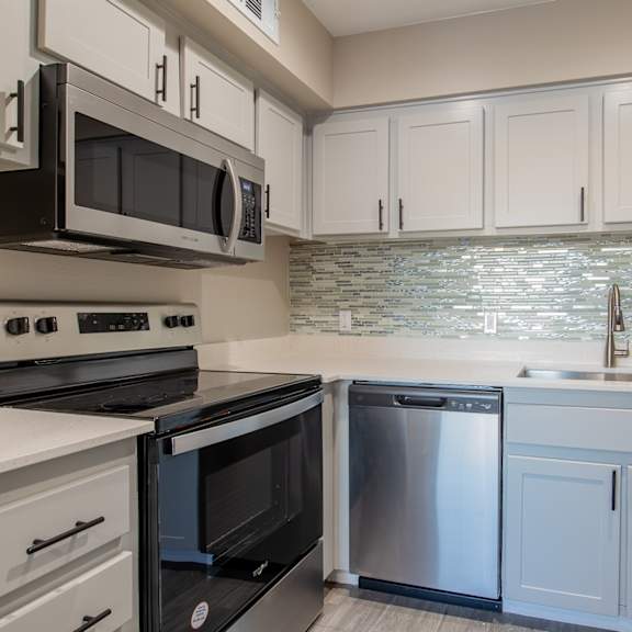 a kitchen with white cabinets and stainless steel appliances  at sofia apartments, tempe, az, 85283