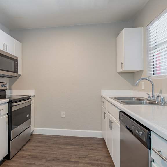 a kitchen with white cabinets and stainless steel appliances