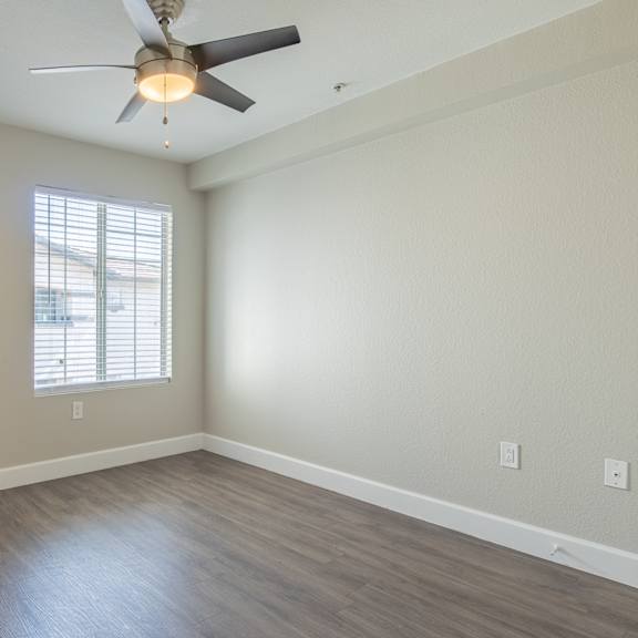 a bedroom with a ceiling fan and a window
