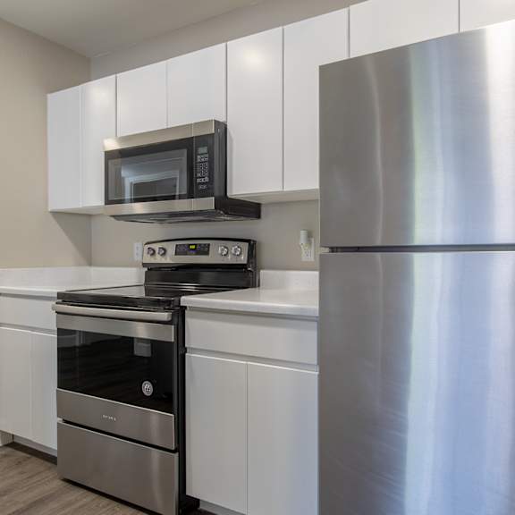 a kitchen with white cabinetry and stainless steel appliances