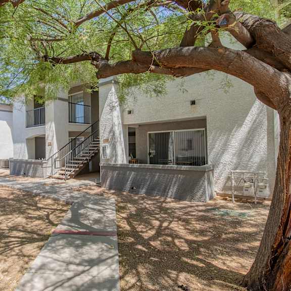 a building with a staircase and trees in front of it