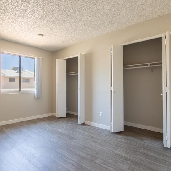 an empty bedroom with a closet and a window