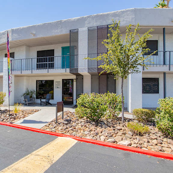 a white building with blue shutters and a yellow line in front of it