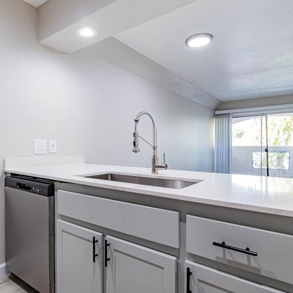 a white kitchen with a sink and a dishwasher at sofia apartments, tempe, 85283