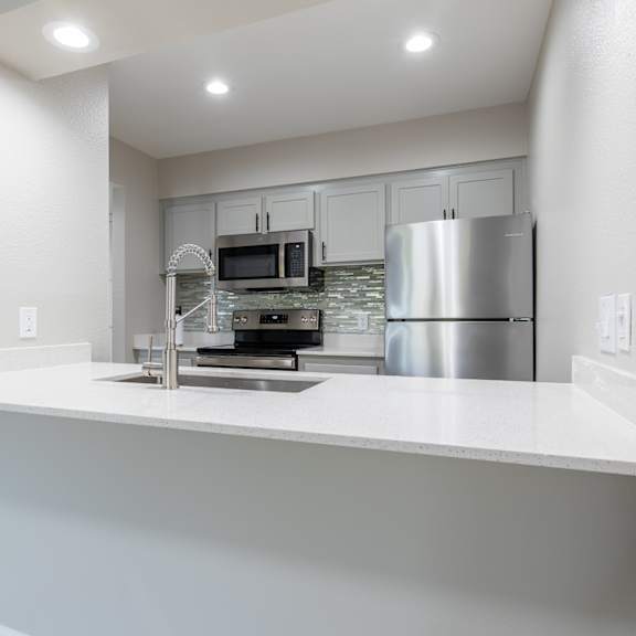 a modern kitchen with a stainless steel refrigerator and a white countertop at sofia apartments, tempe, 85283