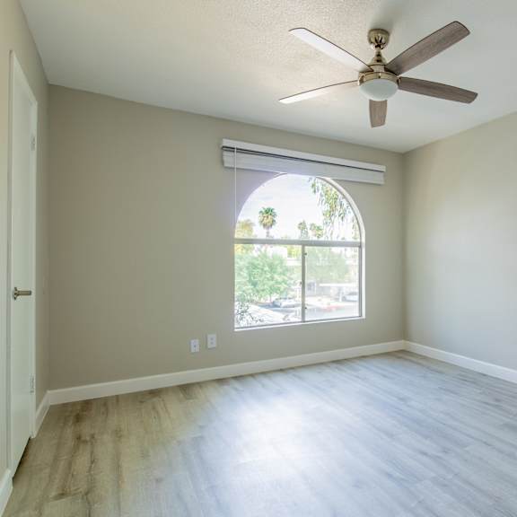 a room with a ceiling fan and a window with blinds at sofia apartments, tempe, 85283