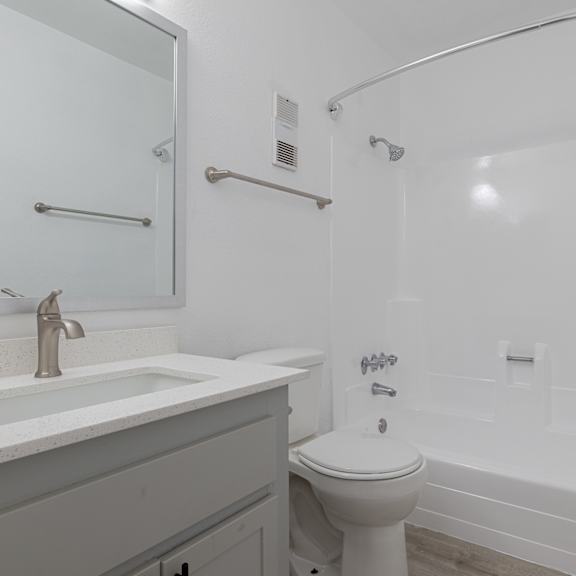 a white toilet sits next to a white sink in a white bathroom at sofia apartments, tempe, 85283