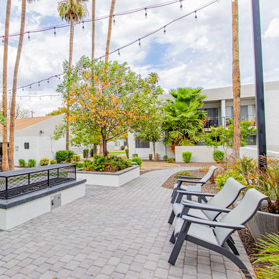 a patio with chairs and a fire pit