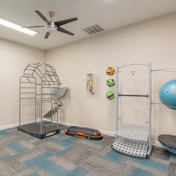a workout room with a yoga ball and a ceiling fan