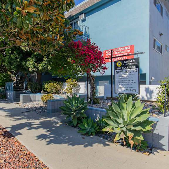 a sidewalk in front of a building with a sign on it
