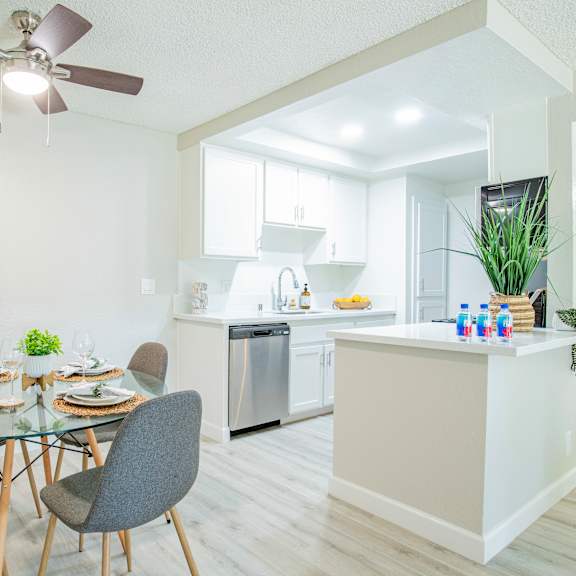 a dining area with a table and chairs and a kitchen in the background at metro 3610, california
