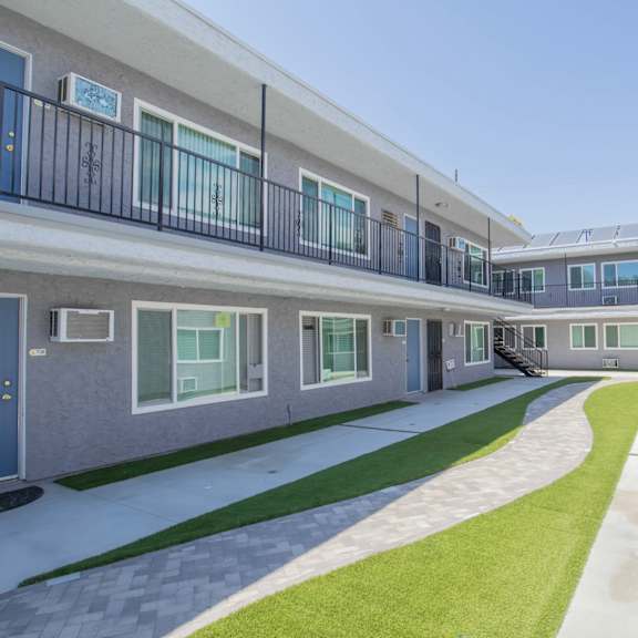 the outlook of a building with balconies and green grass