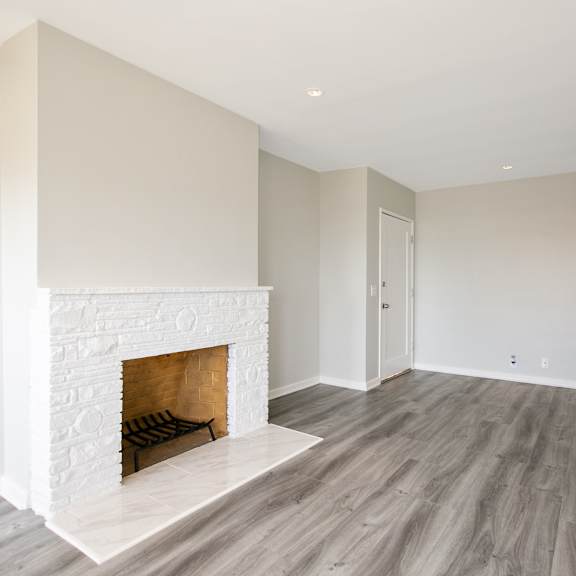 a living room with a fireplace and wooden floors