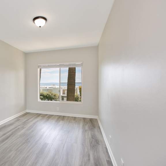 an empty room with white walls and a window